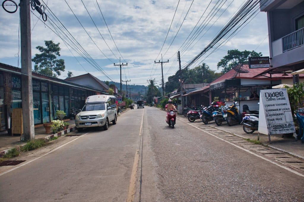 A street on a thai island with scooters.