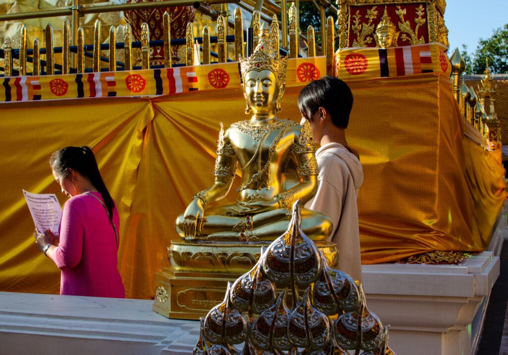 Pielgrzymi modlą się wokół głównej stupy na Doi Suthep w Chiang Mai. 