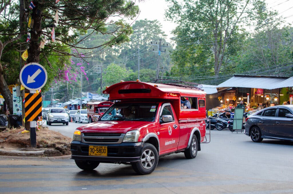 Czerwona taksówka przy świątyni Doi Suthep w chiang Mai skręca w boczną drogę. 