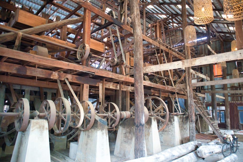 old mill parts with big wheels and wooden beams.