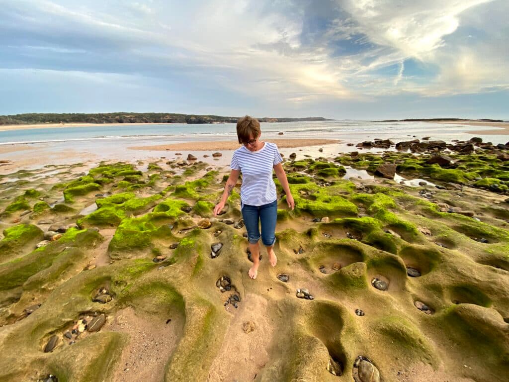 Kobieta chodzi po plaży w Vila Nova de Milfontes, Alentejo.