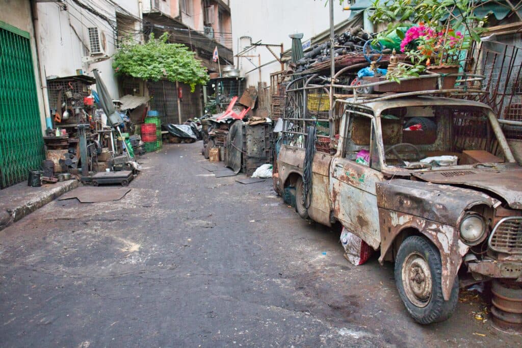Old car and car parts on both sides of the road in bangkok's talad noi.